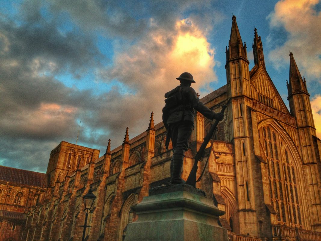 Winchester Cathedral and First World War soldier statue bathed in gorgeous light
