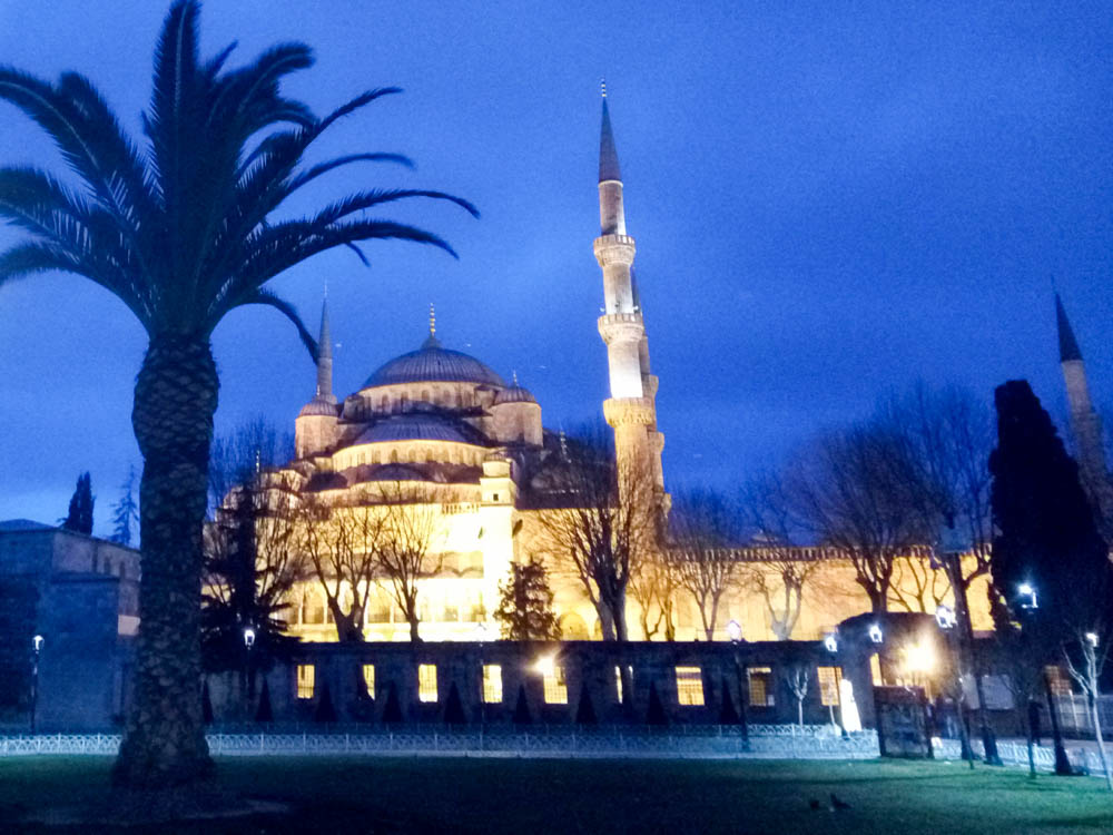 The Blue Mosque at night. The sky is indigo and the building is lit up.