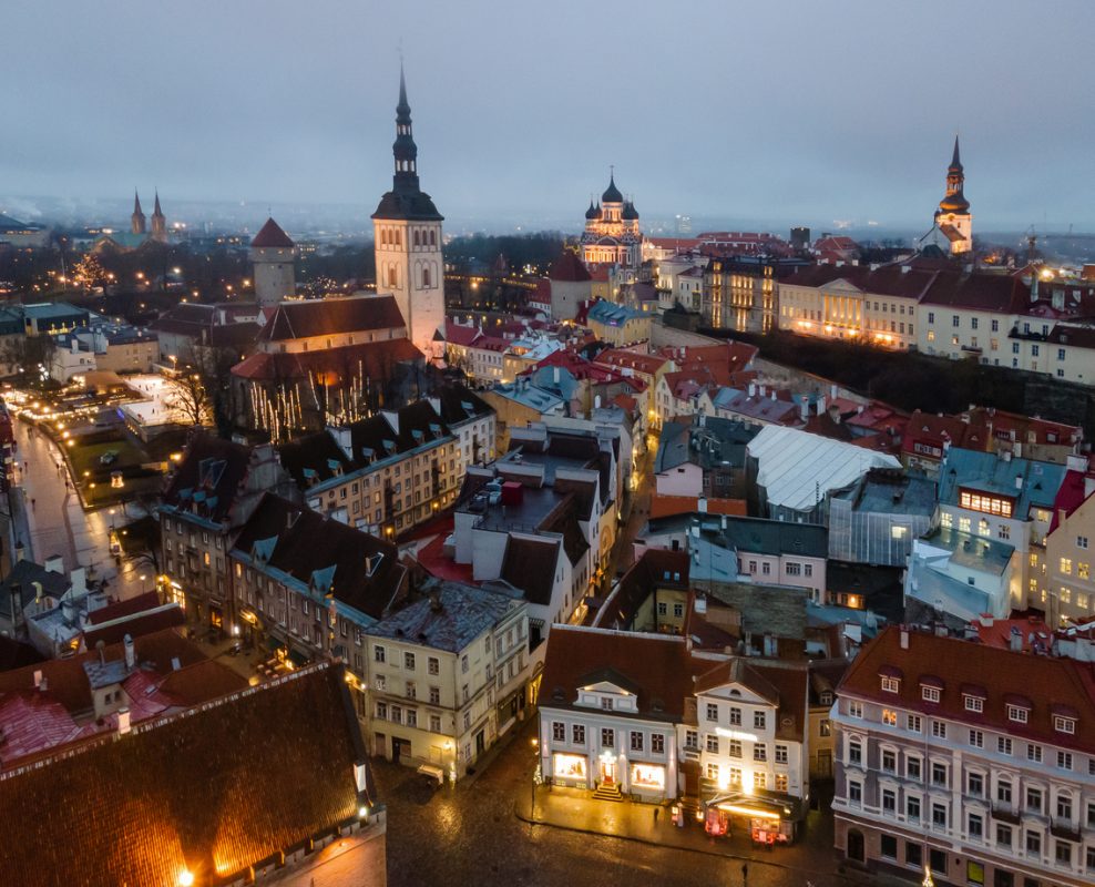 Tallinn, Estonia - December 17 2020: Aerial view to Christmas market in Old Town. Medieval houses with red roofs at evening