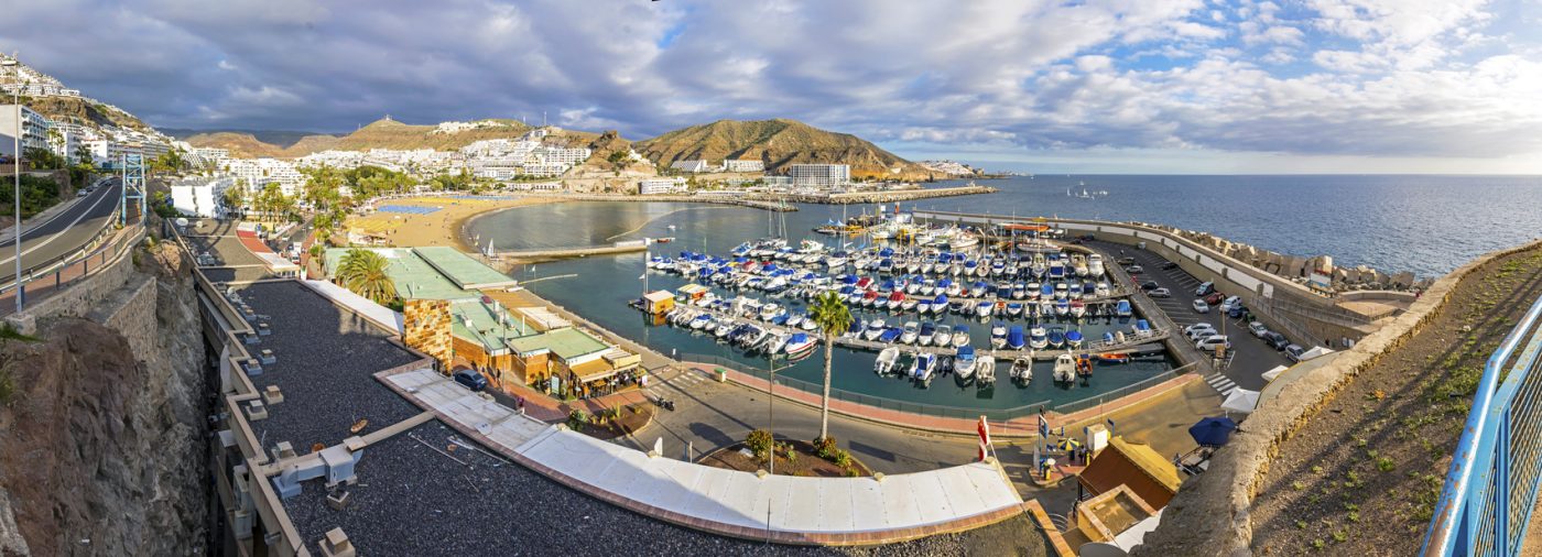 Panoramic aerial view of sea port and small bay of Puerto Rico de Gran Canaria holiday resort. Gran Canaria island, Spain