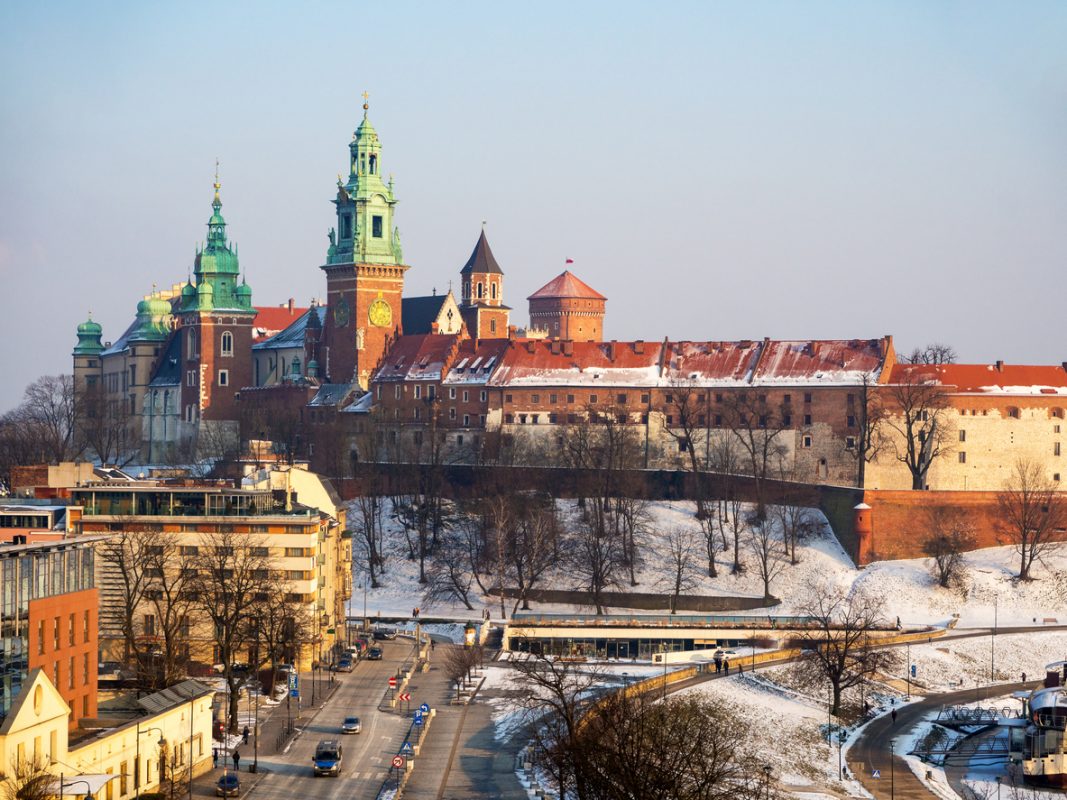 Krakow, Poland. Wawel Cathedral in winter with snow, Vistula river bank . Aerial view in sunset light.