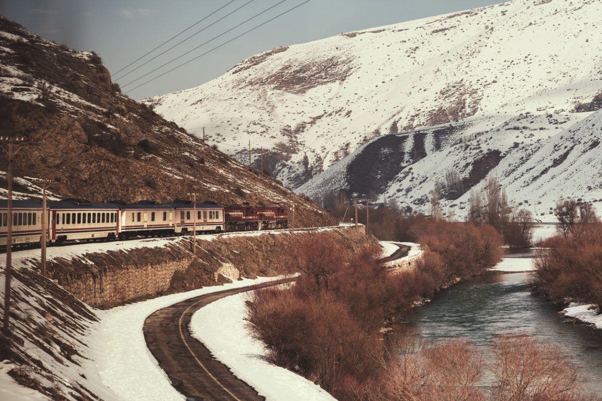Erzincan, Turkey - February 22, 2022: Eastern express train, river and snowy hills in winter season.