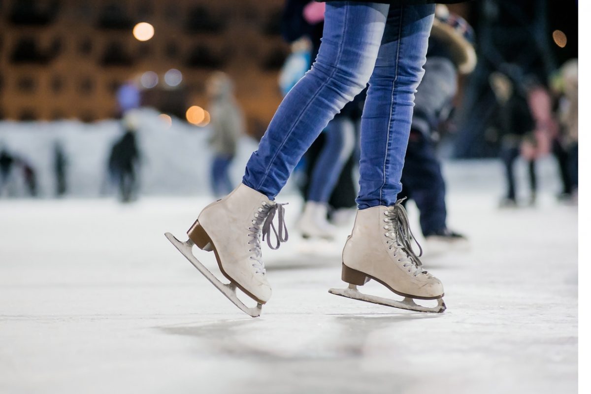 Girl on the figured skates at opened skating rink. Russia.