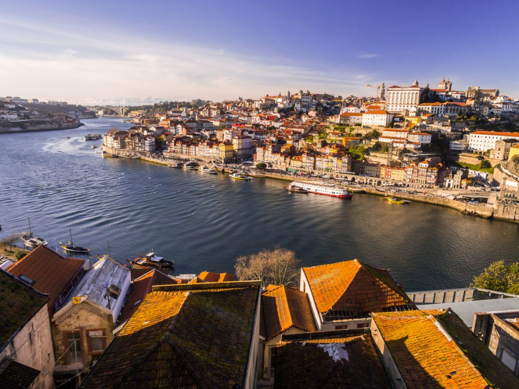 Porto, Portugal – February 12, 2018: Old town of Porto, Portugal, as seen from the other side of Douro river, at sunset.