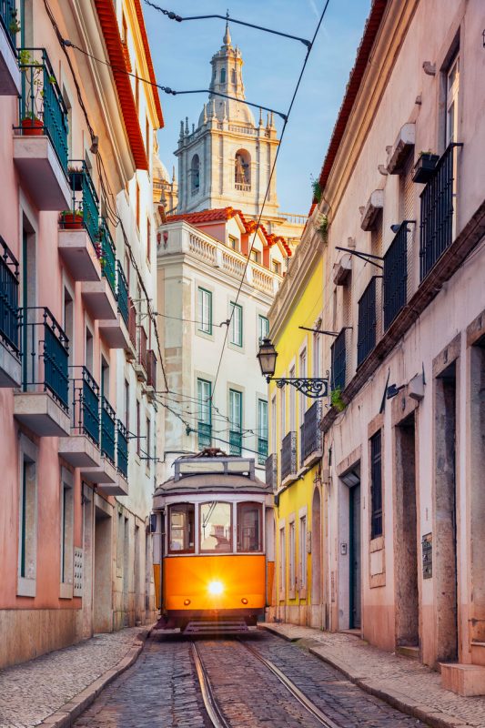 Cityscape image of street of Lisbon, Portugal with yellow tram.
