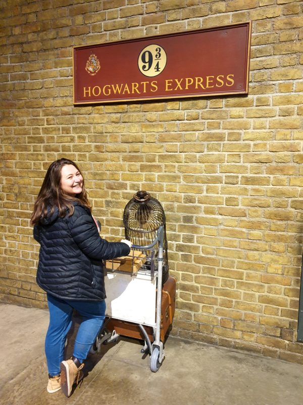Girl at the Warner Bros Studio tour in London in February, taking a photo opportunity of pushing a trolley to platform 9 3/4