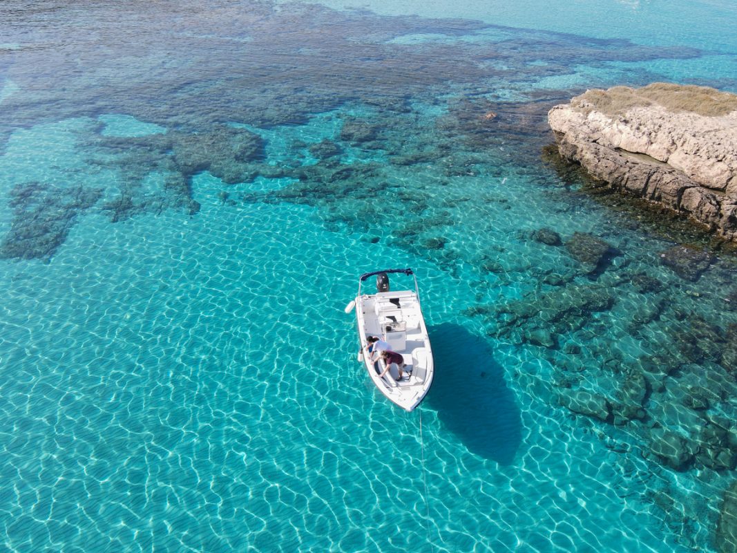 Blue Lagoon in Cyprus with a boat bobbing on the blue water