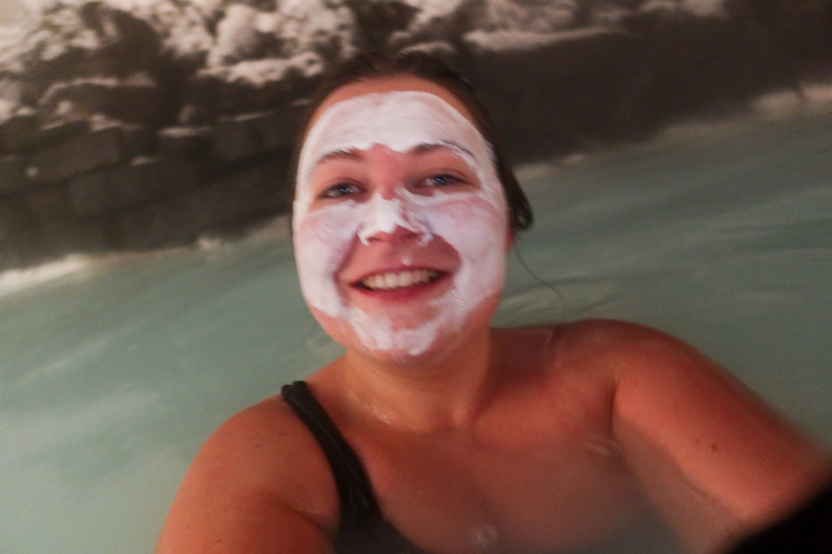 Girl wearing a silica mud mask in the blue lagoon in Iceland.