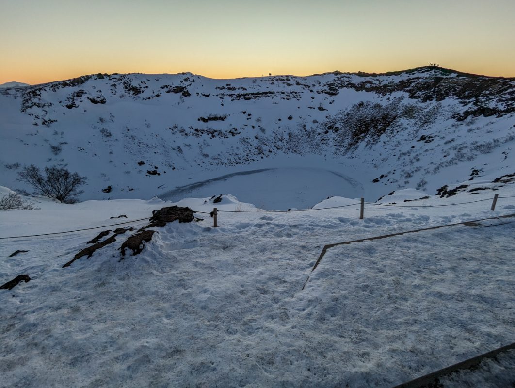 View of Kerid Crater as the sun is rising, covered in snow on the Golden Circle in Iceland in winter.
