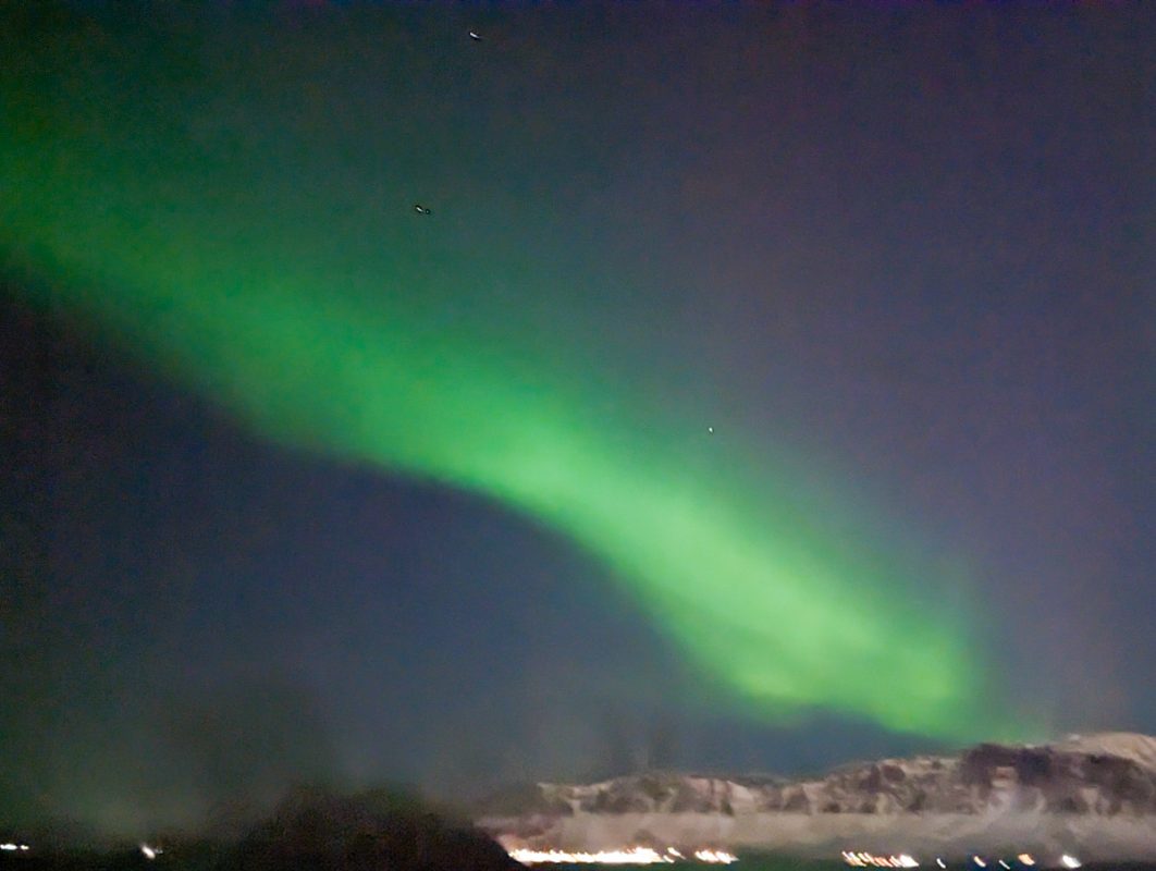 Flashes of green over the snowy hills of Reykjavik.
