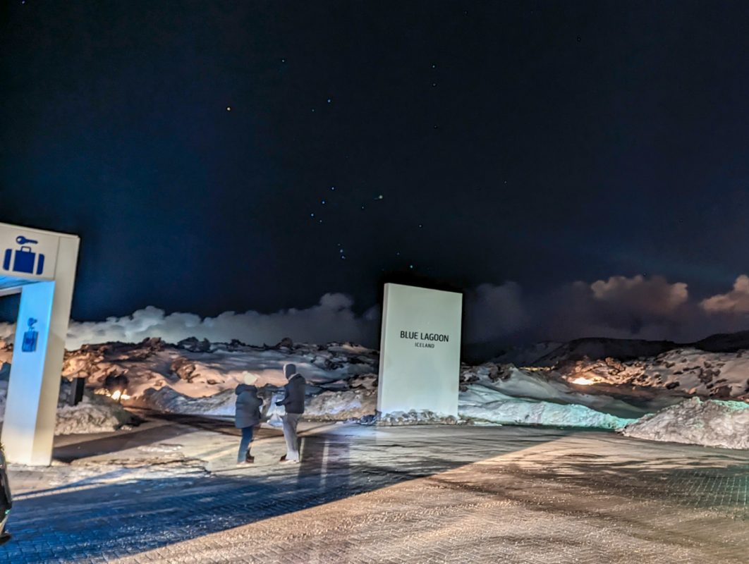 Photo of the outside of the Blue Lagoon, with a sign covered by snow. 