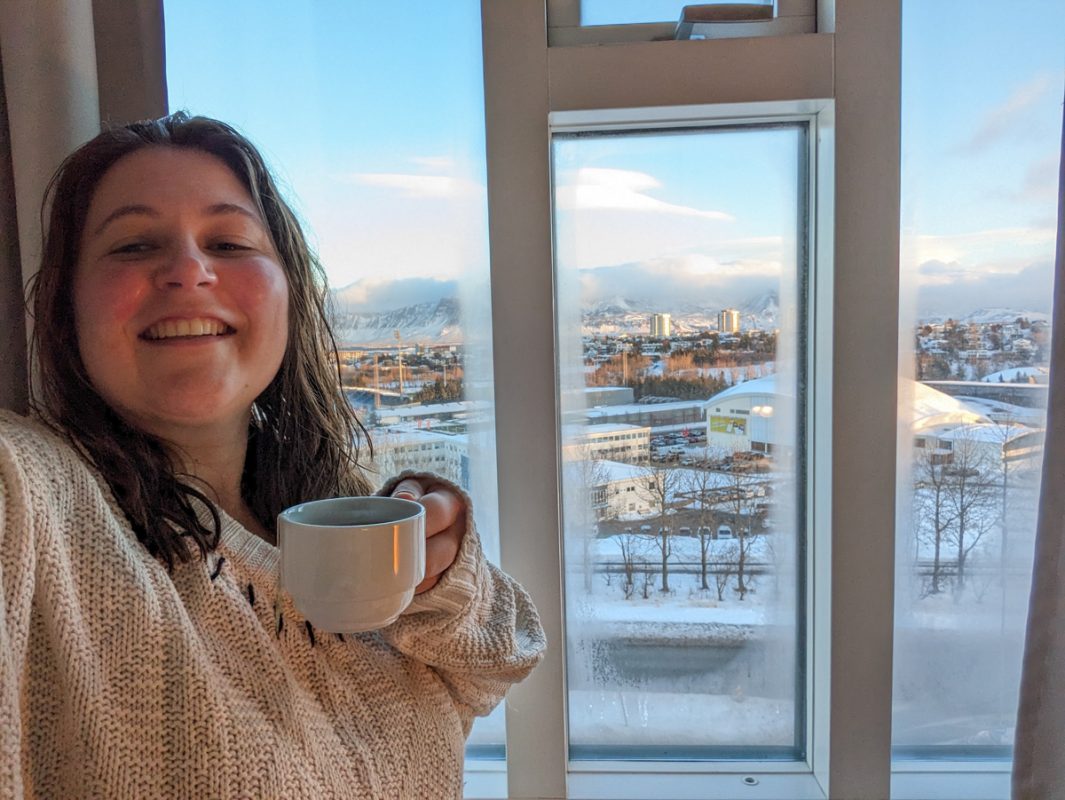 Girl by the window with snowy reykjavik in the background