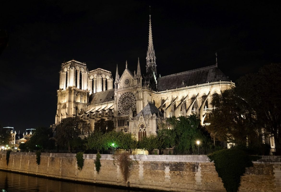 Gothic architecture illuminated against the dark sky in Paris.