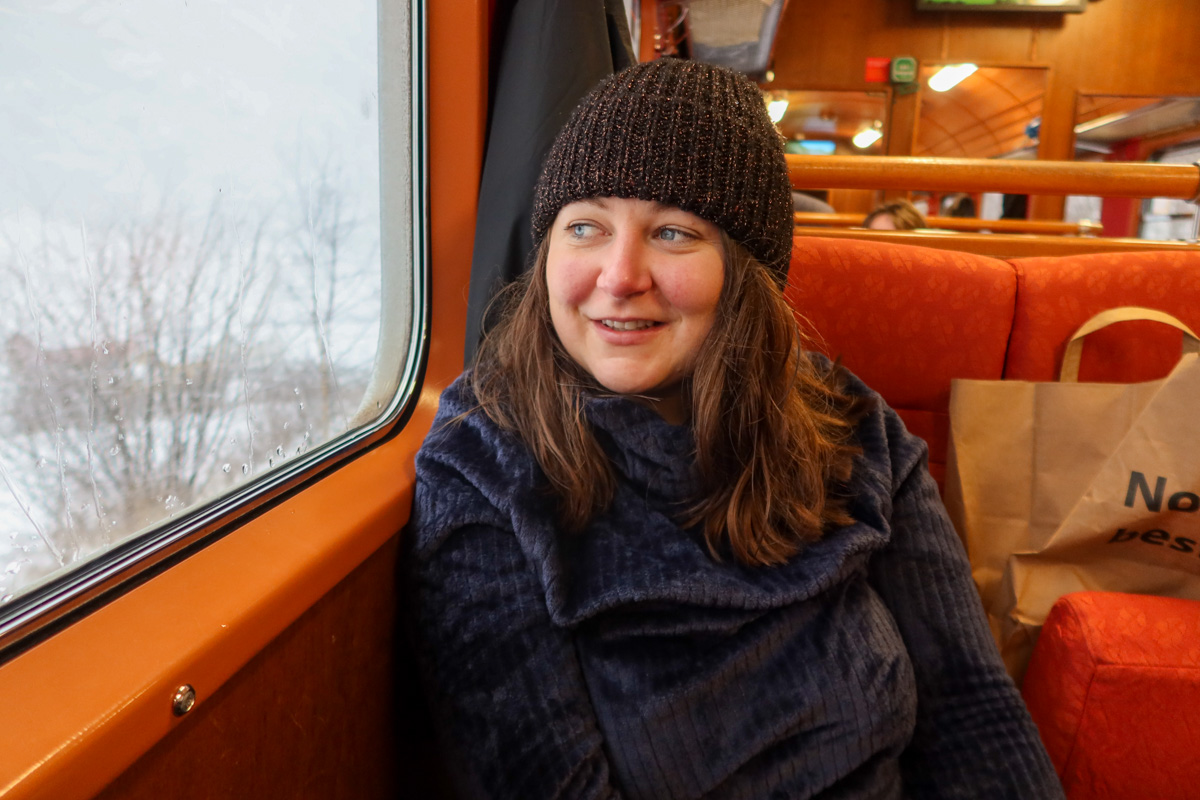 Girl wearing a navy jumper and black hat looking out of the train window