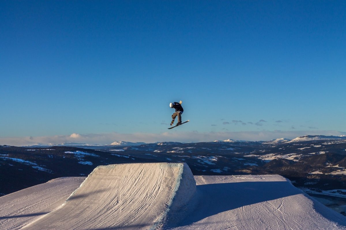 Lillehammer, one of the top skiing destinations in Norway, with a skiier jumping from one of the largest ski jumps. 