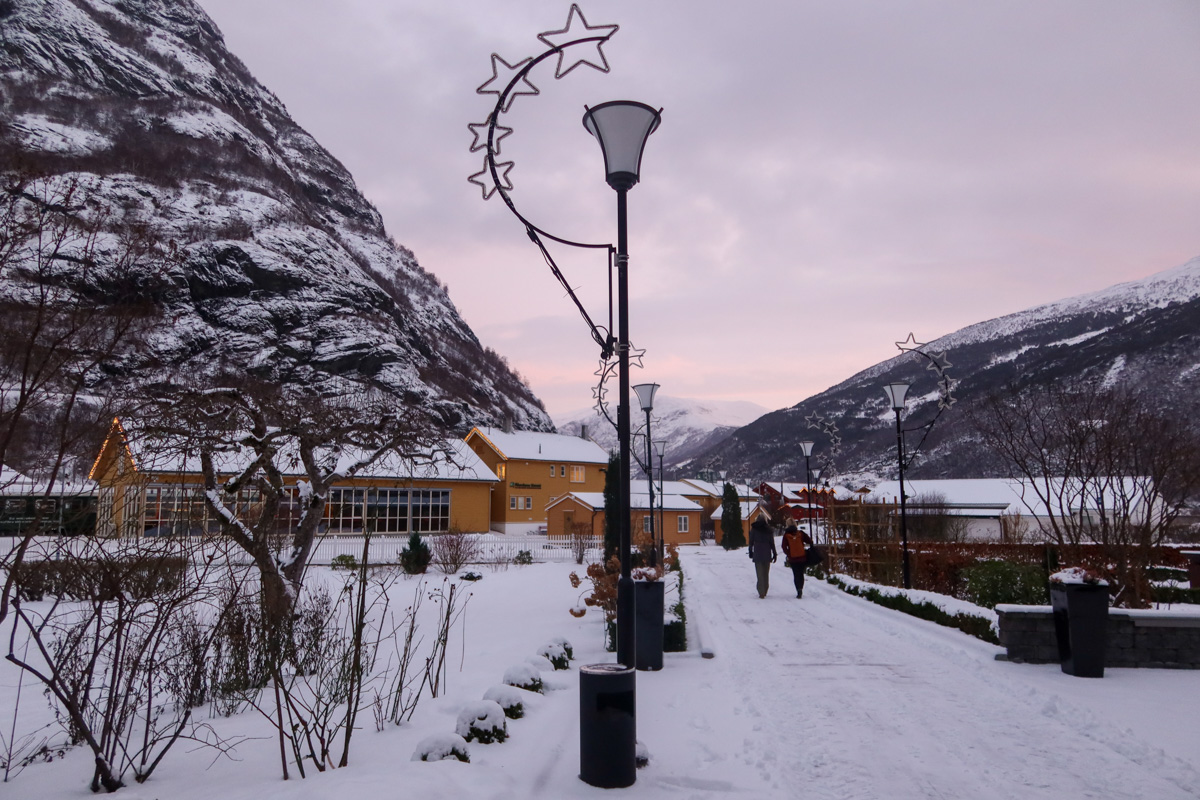 Snowy streets of Flam with lights and cloudy sky in the background