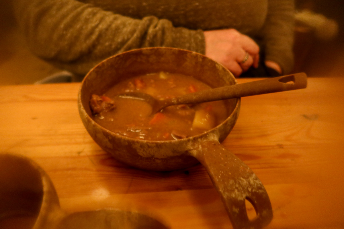 Reindeer stew in a Sami tent at a Sami Ranch. It's on the table and there isn someone's arm in the background