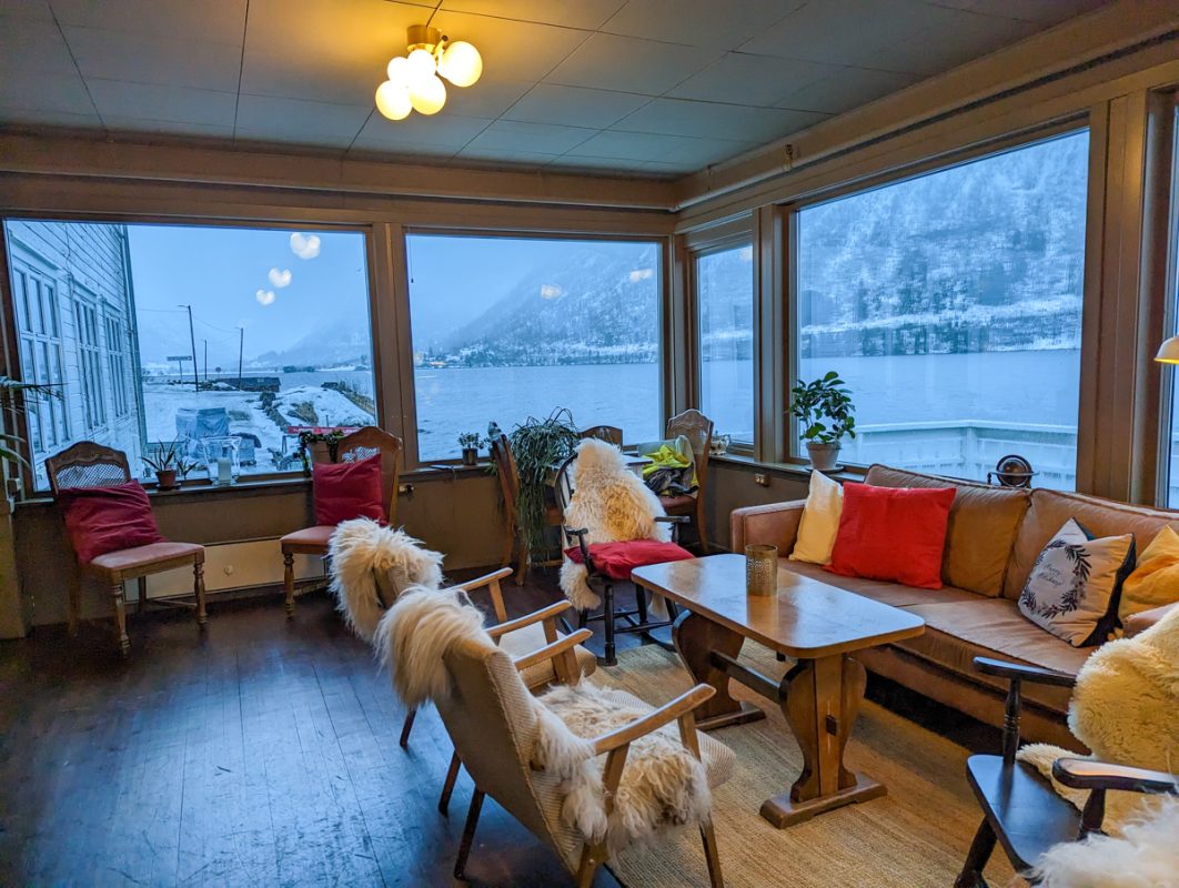 The dining area of Fjaerland Fjordstove hotel, with large windows overlooking snowy fjords