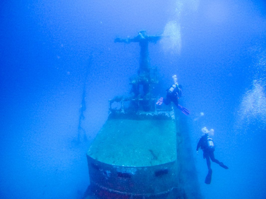 Two divers surrounding the P29 wreck in the sea of Malta
