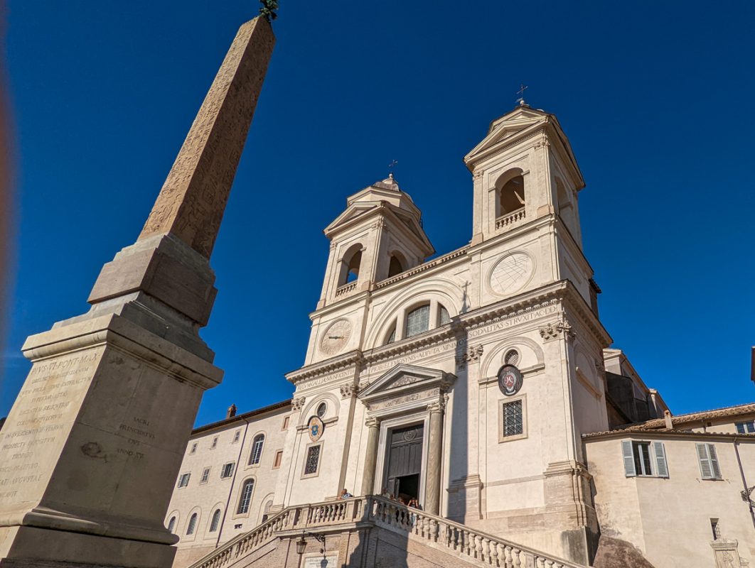 The obelisk and church in piazza del popolo with bright blue sky above