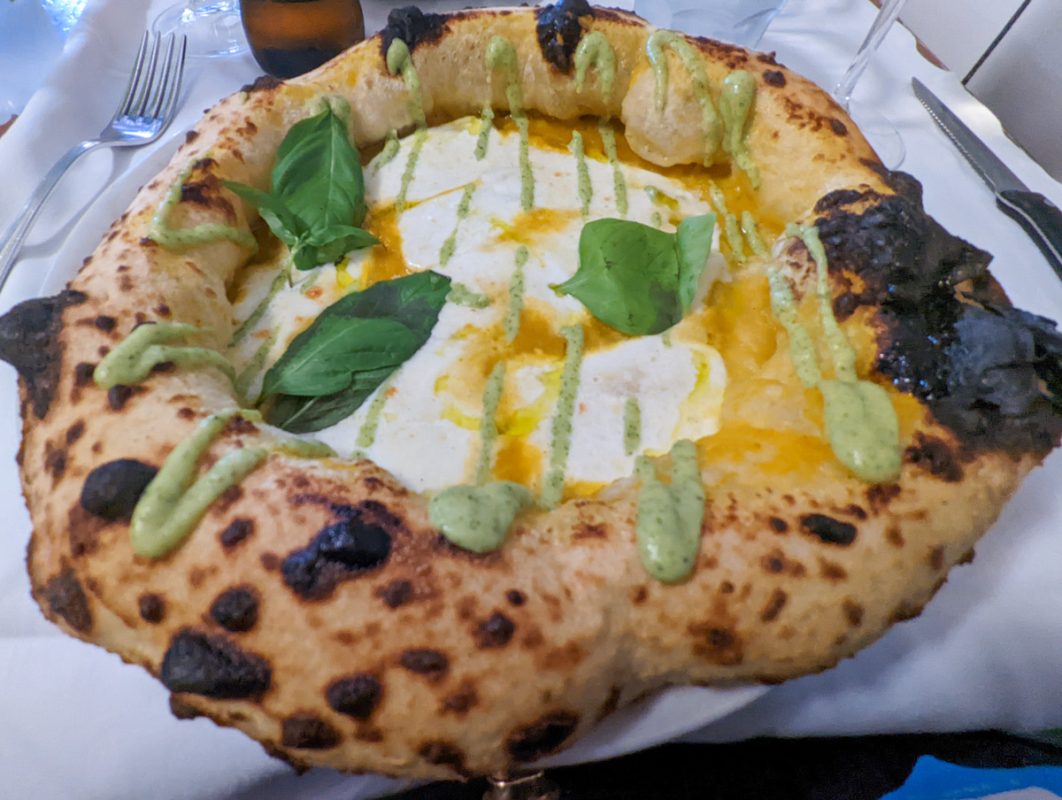 Pizza with cheese and herbs on top