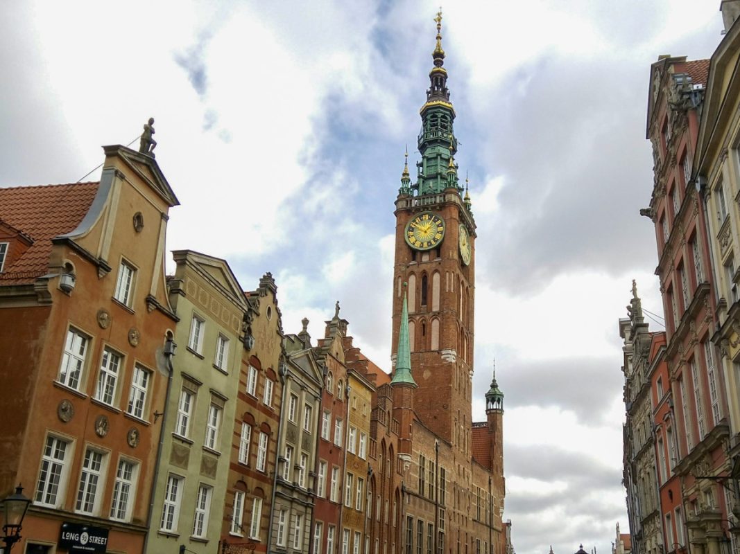 Clock tower looming over the city with green roof in Gdansk.