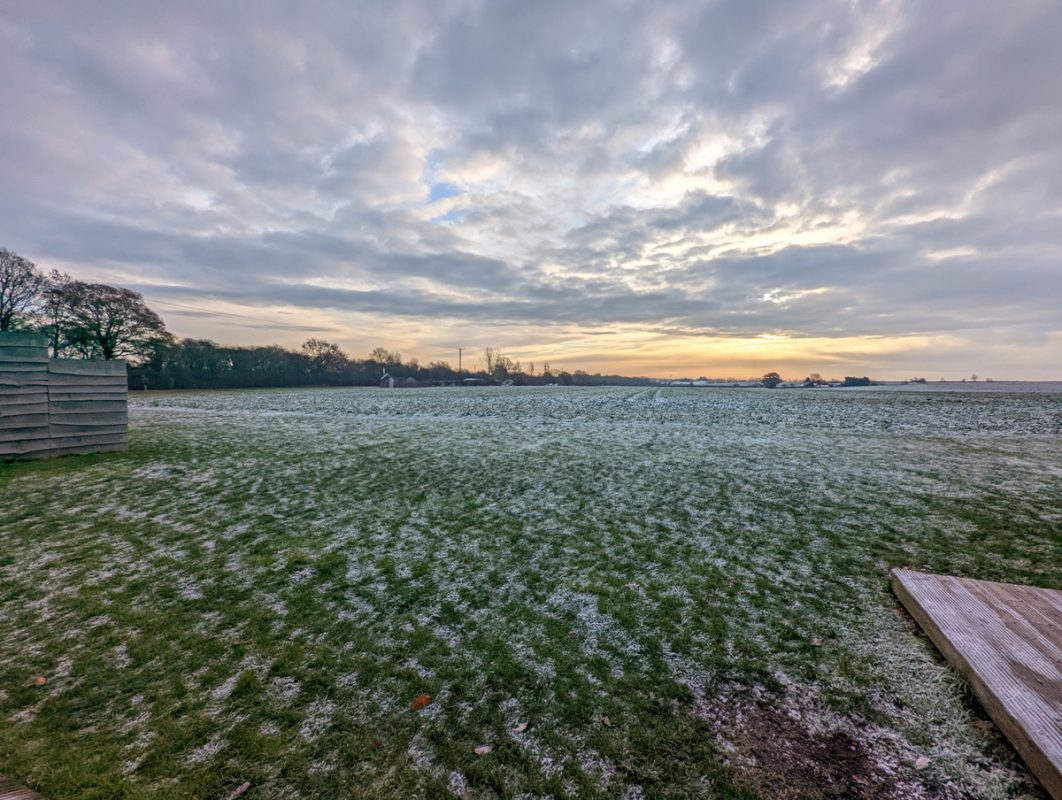 Frosty grass with melted snow and sunrise in the Midlands in England