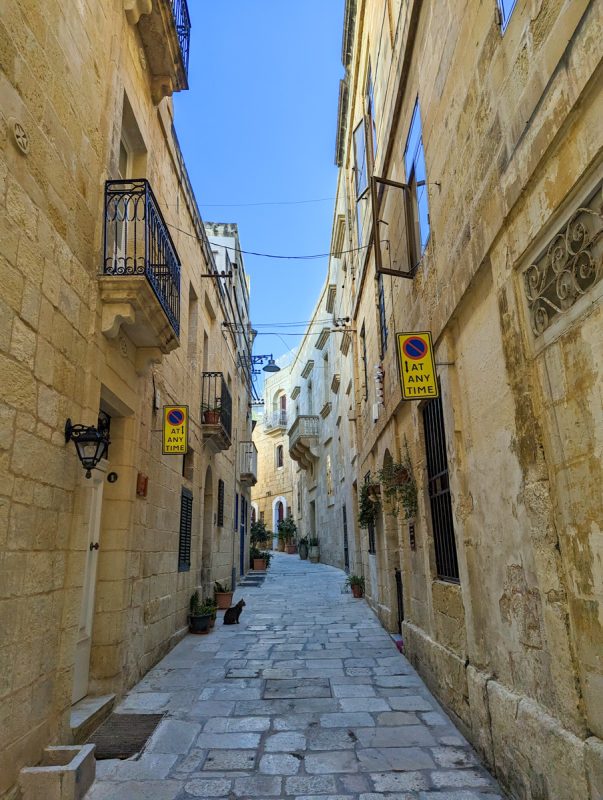Narrow streets of the Three Cities in Malta, cobblestone laneways and golden hued terrace buildings.
