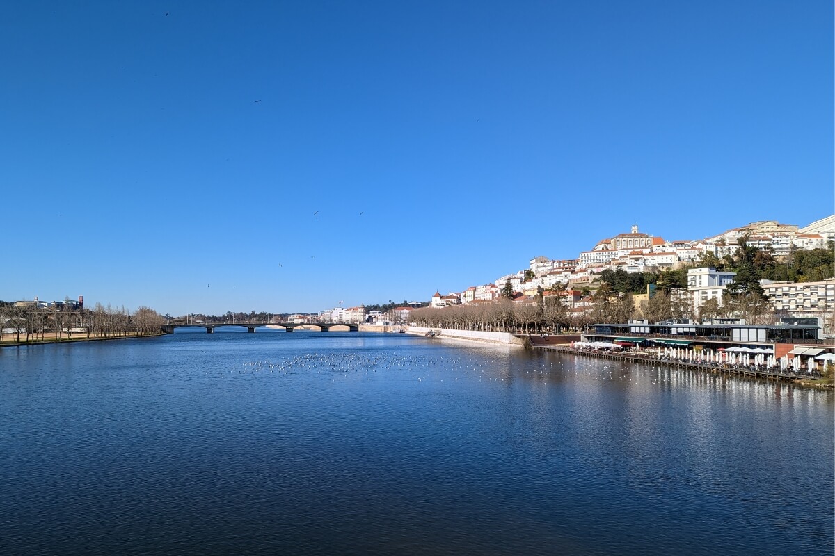 Bridge over bright blue river in Coimbra, Portugal