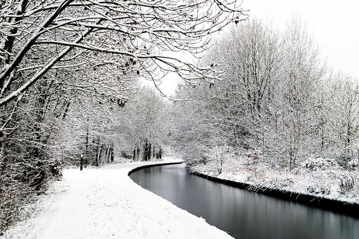 Snowing in England, UK, beautiful winter walk along the path near the canal