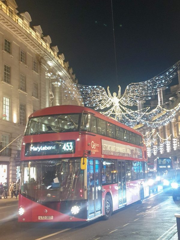 Don't miss the street lights in London in UK in December! A red bus infront of angel lights on Regent Street