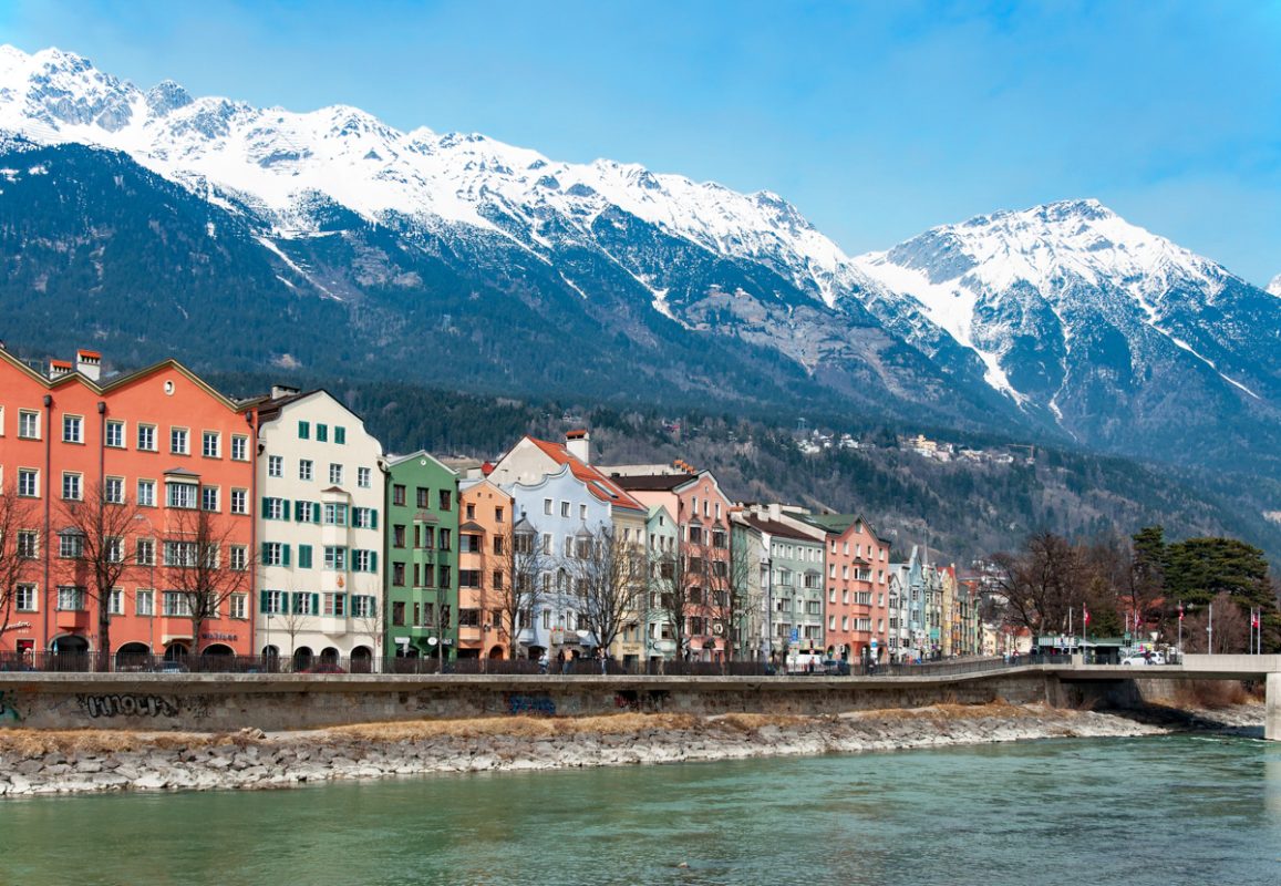 INNSBRUCK, AUSTRIA – MARCH 3, 2010: Inn river, historic houses and, Alps covered with snow in Innsbruck, Tirol, Austria