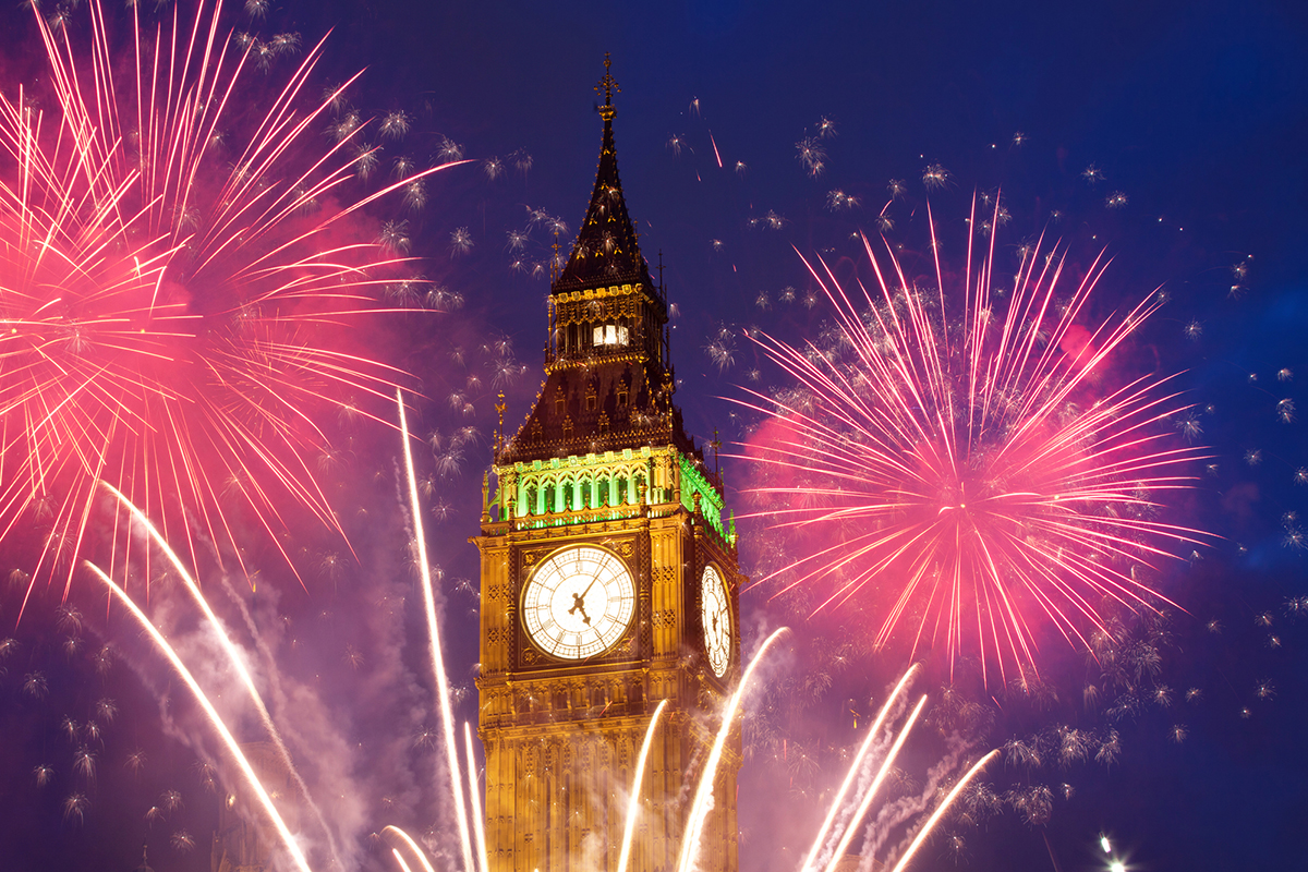Explosive fireworks display fills the sky around Big Ben. New Year's Eve celebration background