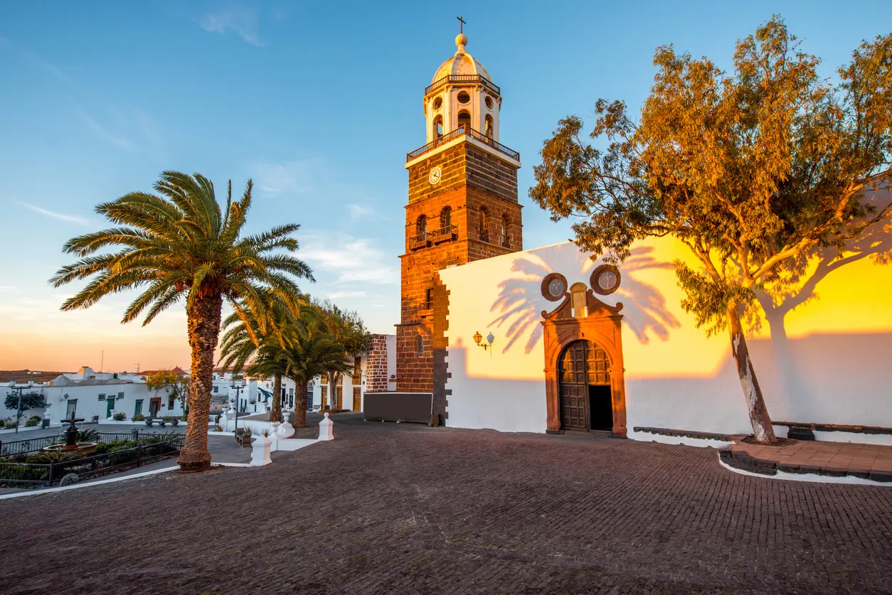 Central square with old church Nuestra Senora de Guadalupe in Teguise village on the sunset on lanzarote island