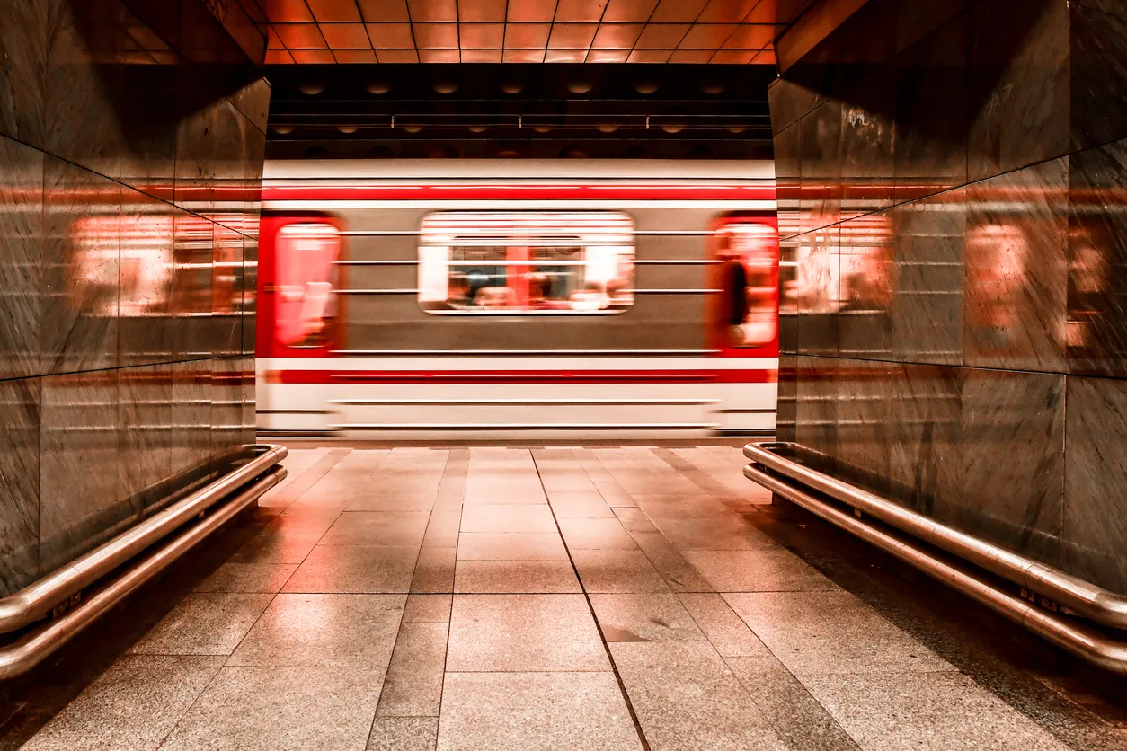 Illuminated underground metro station, public transport in Prague, Czech Republic, departing train from the station.