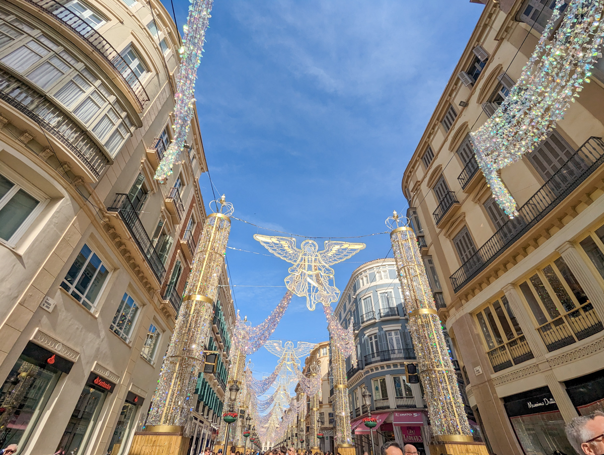 Christmas lights on the Calle de Larios in Malaga, with buildings on either side and angels in the middle.