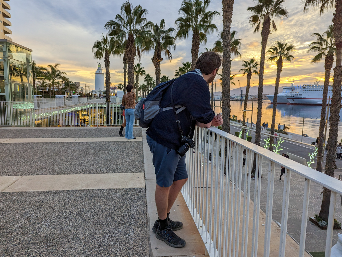Man looking out on the harbour at Malaga in January.
