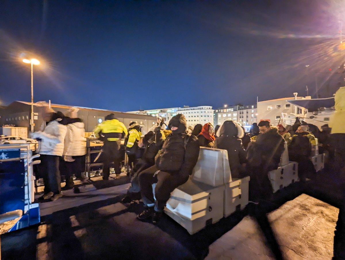 People sitting on the top of the deck on a whale watching boat tour.