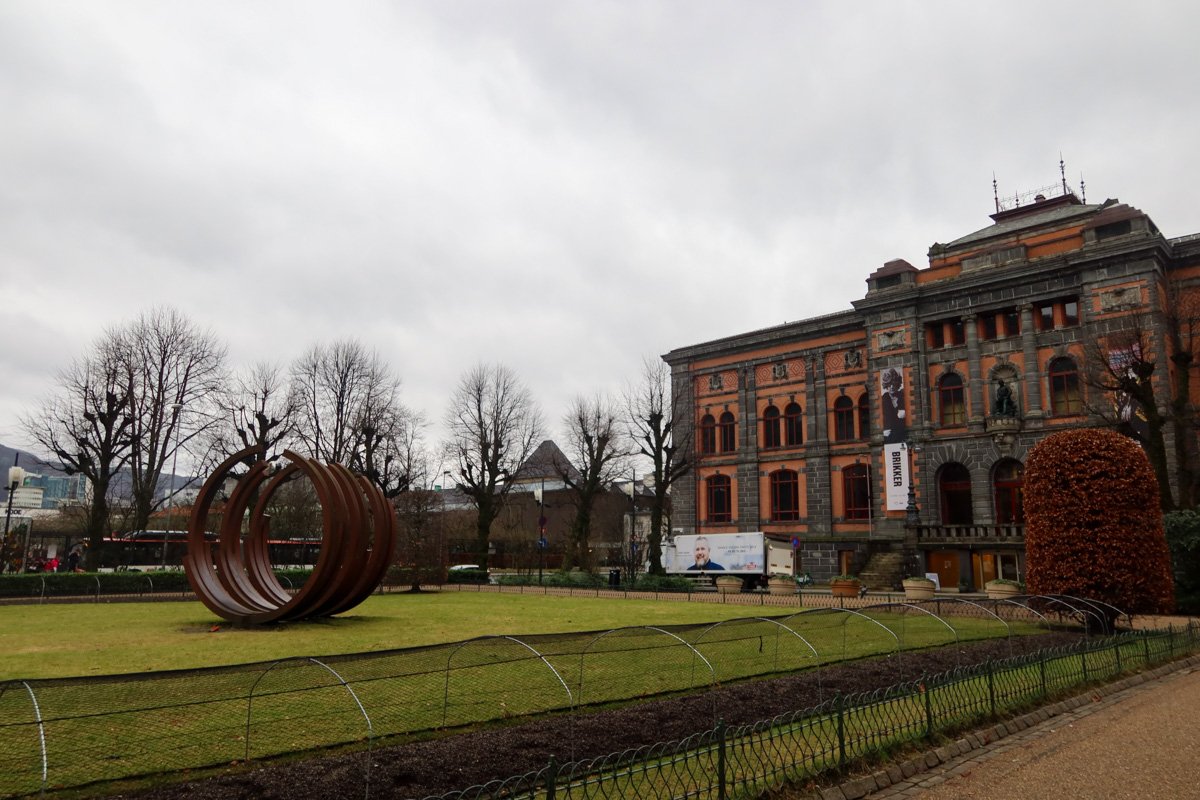 Kode art gallery in Bergen with green bushes and grass in front of the building and the cloudy sky behind it