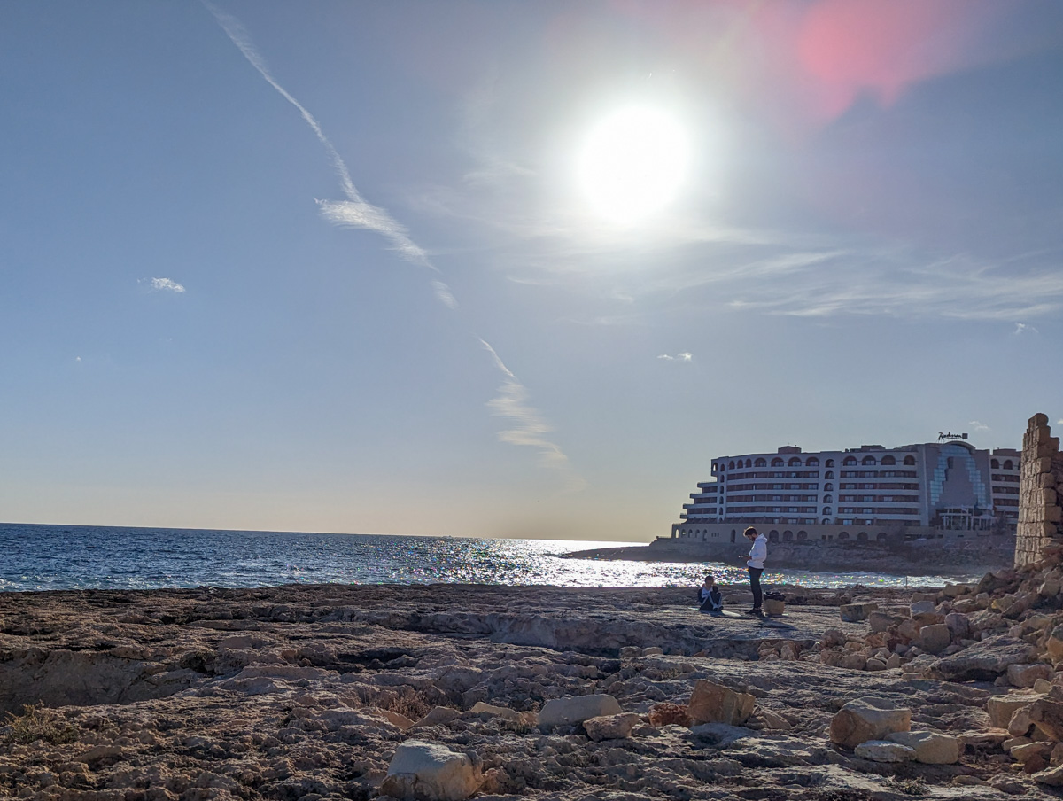 The Radisson Blu Hotel in Malta, with the sea in the background and rocks in the foreground.