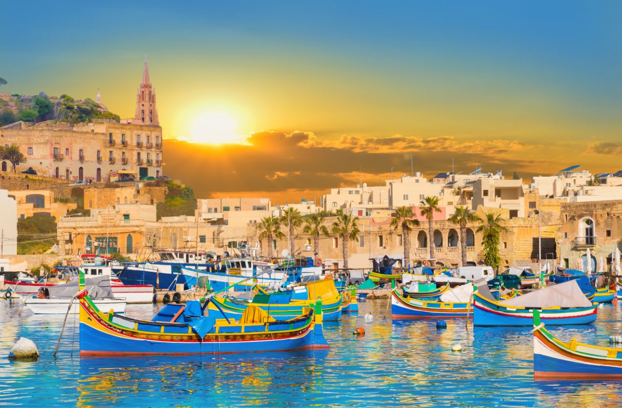 Marsaxlokk village harbor of Malta, illuminate by sunset light