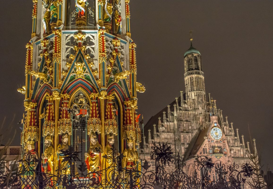 One of the most beautiful landmarks in Nuremberg - Schöner Brunnen in the foreground, and the Frauenkirche in the background, pictured during Traditional Christmas market in the town.