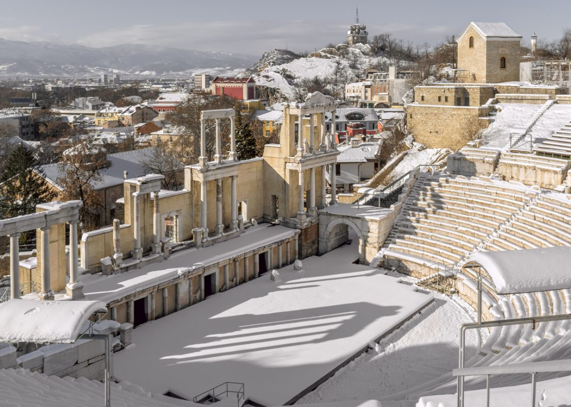 Ancient Roman Theater Philipoppol - landmark and symbol of Plovdiv, cultural, architectural and historical heritage. Winter snowy amphitheatre Philippopolis, Old Town and modern Plovdiv. Bulgaria