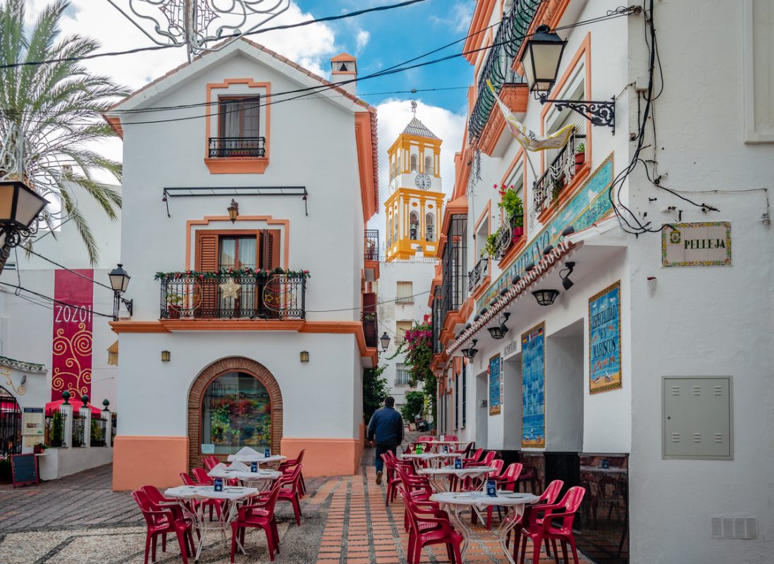 Marbella, Spain - December 21 2014: View of Plaza Altamirano, a pedestrian zone with bars and restaurants in the heart of the old town. The tower of the historic Greater Church of the Encarnacion is in the background.