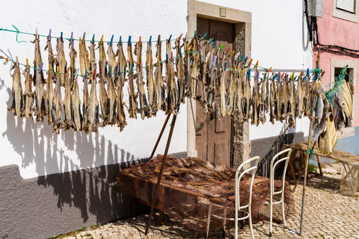 Peniche, Portugal - 2 April, 2022: many strips of salted codfish or bacalao drying in front of a small house in the old town of Peniche
