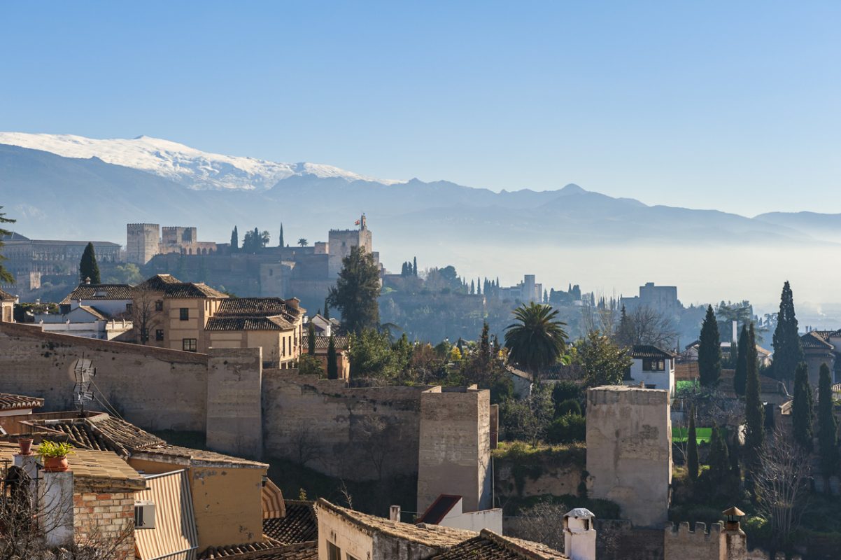 Old skyline of Granada, Andalusia, Spain. The world famous Alhambra and Sierra Nevada mountains can be seen in the distance. Captured on a sunny winterday in december.