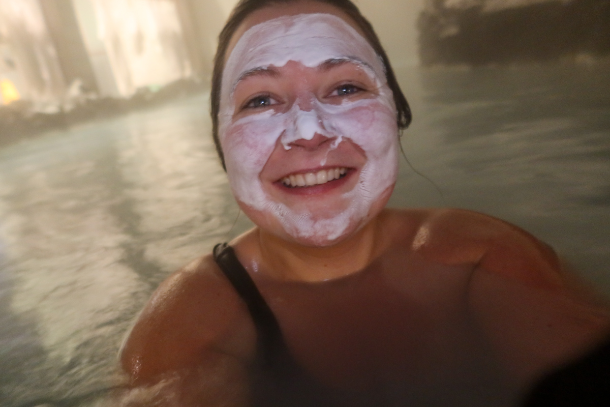 Girl wearing a silica mud mask in the blue lagoon in Iceland.