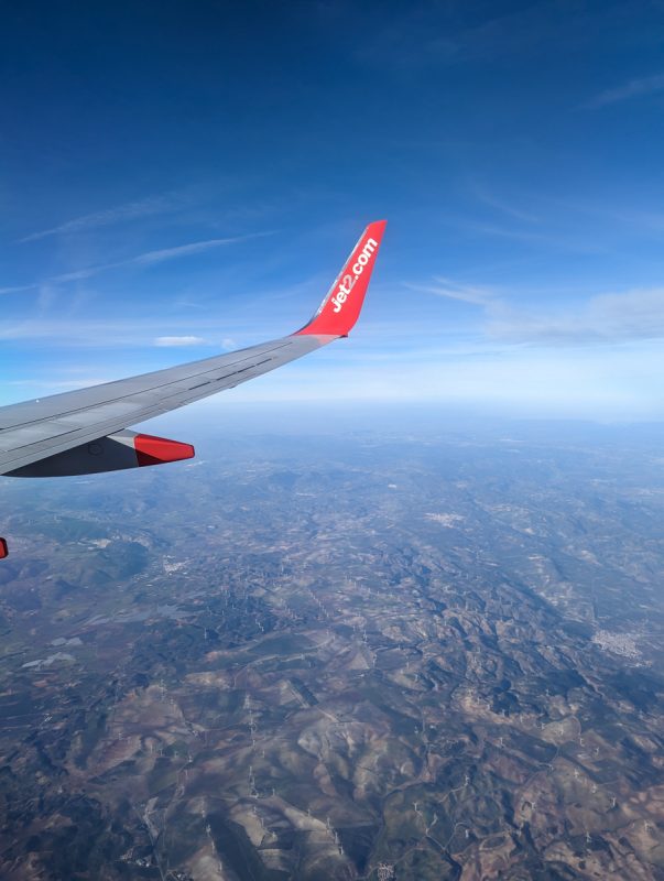 Wing of Jet2 plane on the way to Malaga in winter with mountains in the background