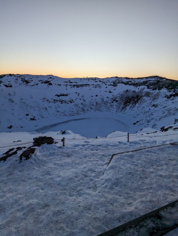 Portrait photo of the frozen Kerid Crater, a snow-covered landscape. 