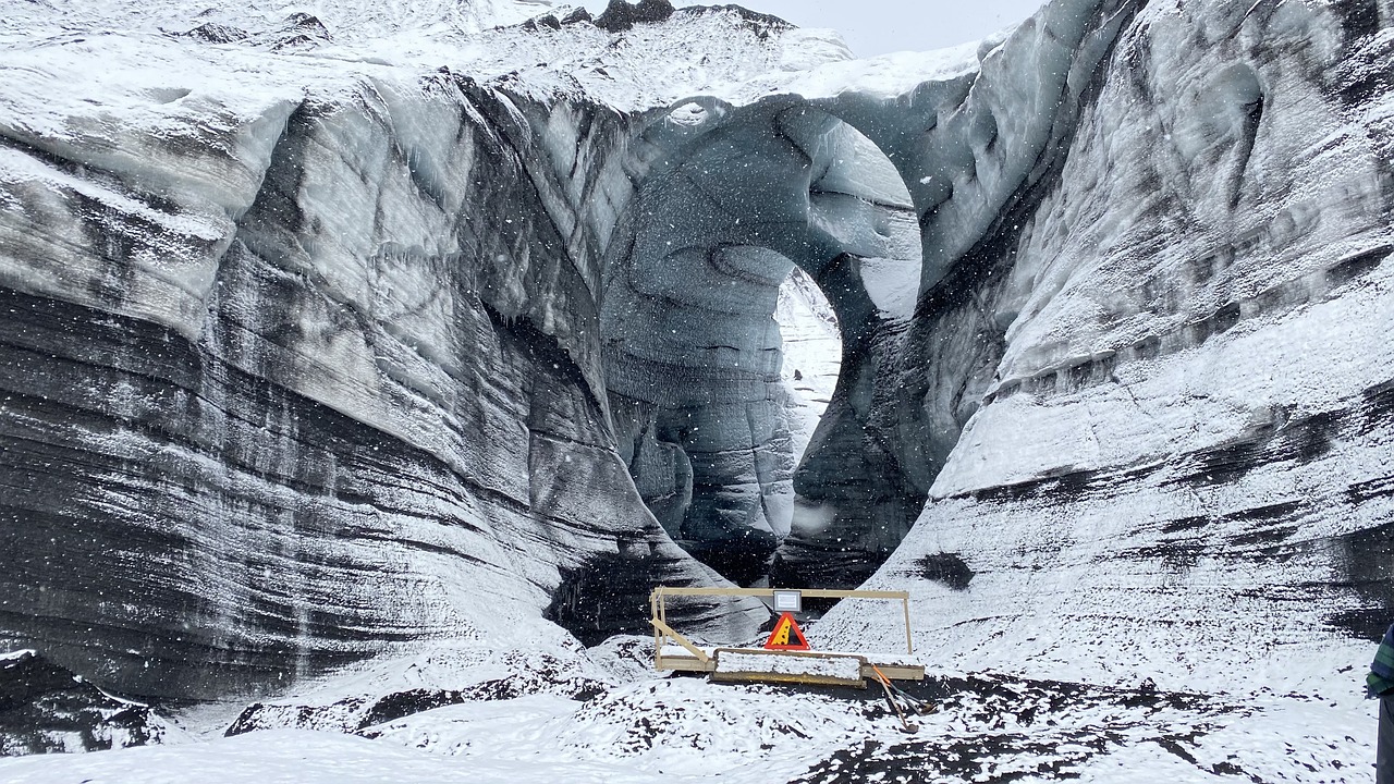 Katla Ice Cave in Iceland - a gaping hole going through the cliffs close to the glacier.